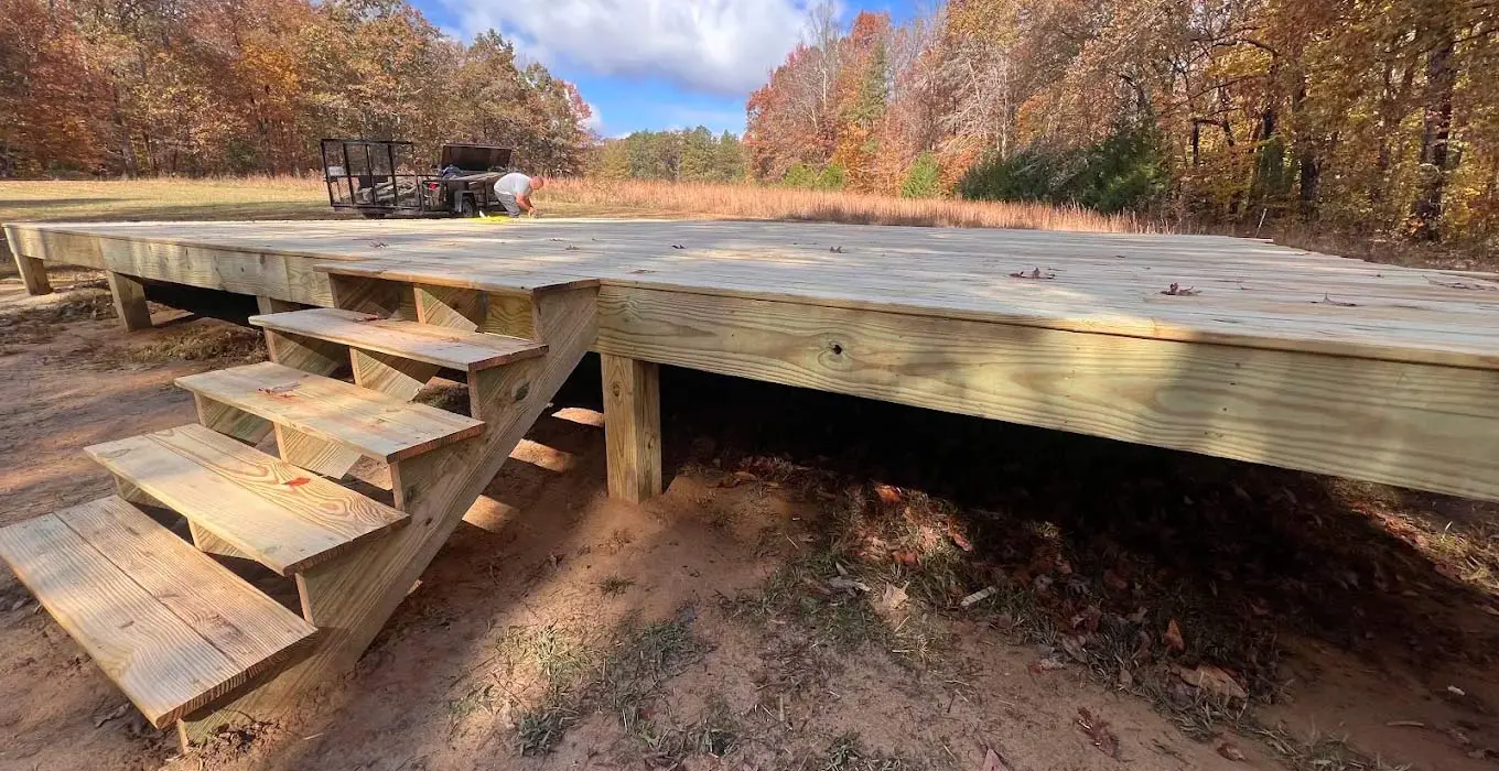 Newly constructed wooden deck with built-in steps leading up to a large platform in a residential yard